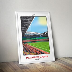 Peut inclure: Une illustration encadrée en blanc du Millennium Stadium à Cardiff, au Pays de Galles. Le stade est représenté avec un terrain vert, des sièges rouges et un toit blanc.