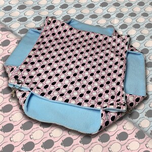 Op de afbeelding: Een blauw en roze bed met een patroon voor huisdieren met een zachte, pluche voering. Het bed is ontworpen voor kleine dieren zoals hamsters of ratten.