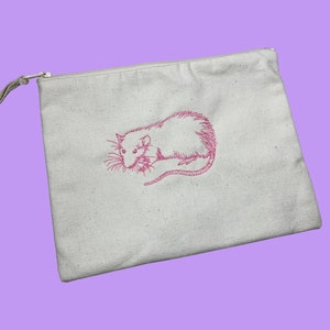 May include: A white canvas zippered pouch with a pink embroidered image of a rat.