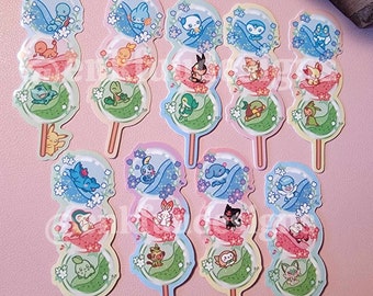 Puede incluir: Un conjunto de 10 pegatinas coloridas con varios personajes de Pokémon en un diseño de dango (bolita japonesa). Cada pegatina tiene tres capas de dango, con un personaje de Pokémon diferente en cada capa. Las pegatinas son perfectas para agregar un toque de fantasía a las computadoras portátiles, las botellas de agua u otras superficies.
