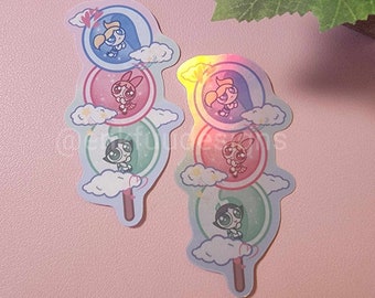 May include: Two holographic stickers featuring the Powerpuff Girls in a stack of colorful bubbles. Each sticker has a different color scheme and features the three girls in different positions.