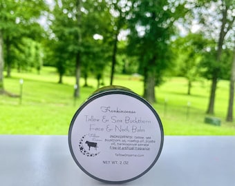 May include: A round jar of Frankincense Tallow & Sea Buckthorn Face & Neck Balm. The label includes the product name, ingredients, and the brand's logo with a cow silhouette. The jar is 2 oz.