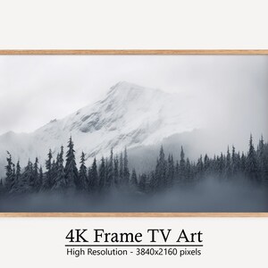 Könnte beinhalten: Ein gerahmtes Foto einer schneebedeckten Bergkette mit einem Wald aus immergrünen Bäumen im Vordergrund. Das Bild ist in Grautönen und Blau gehalten und erzeugt eine stimmungsvolle und atmosphärische Stimmung.