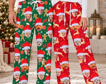 May include: Two pairs of lounge pants featuring a repeating pattern of faces wearing Santa hats, interspersed with gingerbread men, candy canes, and snowflakes on green fabric, and reindeer and snowflakes on red fabric, with white drawstrings.