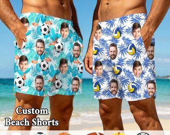 May include: Two pairs of custom beach shorts featuring repeating patterns of faces and sports balls. The left pair has a light blue background with flamingos and soccer balls. The right pair has a white background with blue palm leaves and volleyballs.