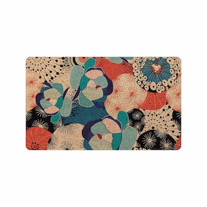 Puede incluir: Una alfombra de bienvenida con un estampado floral y geom&eacute;trico colorido. El dise&ntilde;o presenta colores azules, rojos y beige sobre un fondo marr&oacute;n.