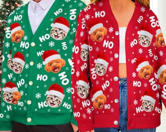 May include: A green button-down cardigan and a red button-down cardigan, both featuring a repeating pattern of cats and dogs wearing Santa hats, white snowflakes, and the text "HO" printed in white across the fabric of each garment.