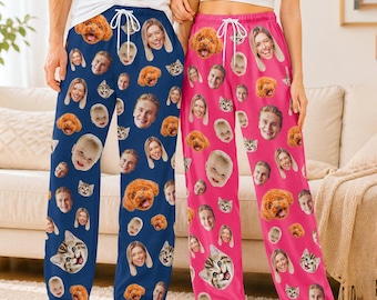 May include: Two pairs of lounge pants featuring a repeating pattern of various human and pet faces. One pair is dark blue and the other is bright pink. Both pairs have a white drawstring at the elastic waistband and a loose, straight-leg fit.