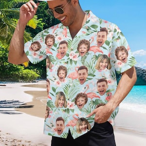 May include: A light blue short-sleeved button-up shirt with a tropical print featuring multiple faces and pink flamingos.