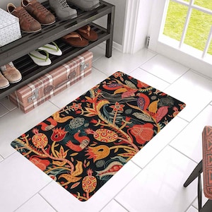 Puede incluir: Una alfombra de bienvenida colorida con fondo negro y un patr&oacute;n floral con flores y p&aacute;jaros rojos, naranjas, amarillos y azules.
