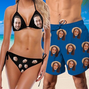 May include: A black bikini with a face print on the top and bottom. A blue swim trunk with a face print.