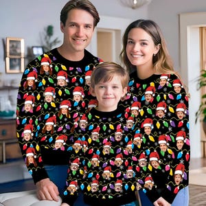 Könnte beinhalten: Eine dreiköpfige Familie trägt passende Weihnachtspullover mit schwarzem Hintergrund und einem Muster aus bunten Weihnachtslichtern und Gesichtern.