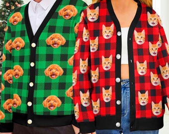 May include: Two button-up cardigans featuring repeating patterns of animal faces. The left cardigan is green and black plaid with brown dog faces, while the right cardigan is red and black plaid with orange cat faces, both with black trim.