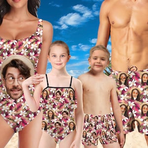 Peut inclure: Une famille de quatre personnes portant des maillots de bain assortis avec un imprimé floral tropical représentant des visages. Les maillots de bain sont roses, noirs et blancs. Les adultes portent des maillots de bain une pièce et les enfants portent des shorts de bain et un maillot de bain une pièce.