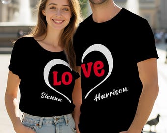 May include: Two black short-sleeved t-shirts featuring a white heart outline design. The left shirt displays the red text 'LO' and the name 'Sienna' in white. The right shirt displays the red text 've' and the name 'Harrison' in white.