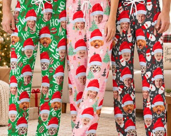 May include: Three pairs of lounge pants featuring a repeating pattern of human and pet faces wearing Santa hats. The pants come in green, pink, and black, each with a white drawstring waist and festive holiday motifs like trees and ornaments.