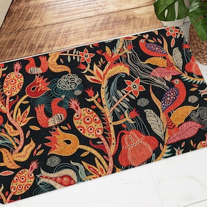 Puede incluir: Una colorida alfombra de bienvenida con un dise&ntilde;o floral y de p&aacute;jaros. La alfombra tiene un fondo oscuro con acentos rojos, naranjas, amarillos y azules. El dise&ntilde;o es intrincado y detallado, con una variedad de flores, hojas y p&aacute;jaros.