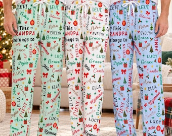 May include: Three pairs of pajama pants in light green, white, and light blue, each featuring a repeating pattern of Christmas trees, red gift boxes, ornaments, and the text "This GRANDPA belongs to" alongside various names like Levi and Emma.