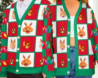 May include: A V-neck cardigan featuring a red and white checkerboard pattern with repeating graphics of cats and dogs wearing reindeer antlers, wrapped gift boxes, Christmas trees, and colorful string lights, finished with green trim.