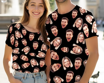 May include: Two black short-sleeved t-shirts featuring an all-over repeating pattern of various smiling faces. The shirts have a crew neckline and a standard fit, displaying a collage of different facial expressions printed across the fabric.