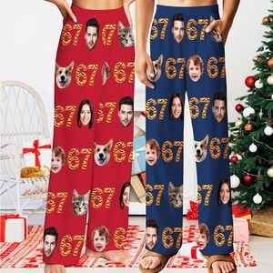 May include: Red and blue pajama pants with a repeating pattern of faces, cat faces, dog faces, and the number "67" in a tiger stripe design. The pants are loose-fitting and appear to be made of a soft material.