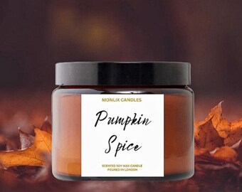 May include: A brown glass jar candle with a black lid and a white label that reads "Pumpkin Spice" and "Scented Soy Wax Candle Poured in London". The candle is sitting on a bed of brown and orange autumn leaves.