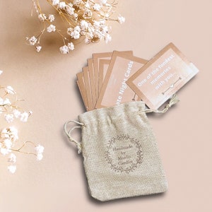 May include: A set of brown date night cards in a small burlap bag with a white logo that says "Handmade by Monlix Candles". The cards have white text that says "One of the fondest memories with you..." and "Date Night Cards".