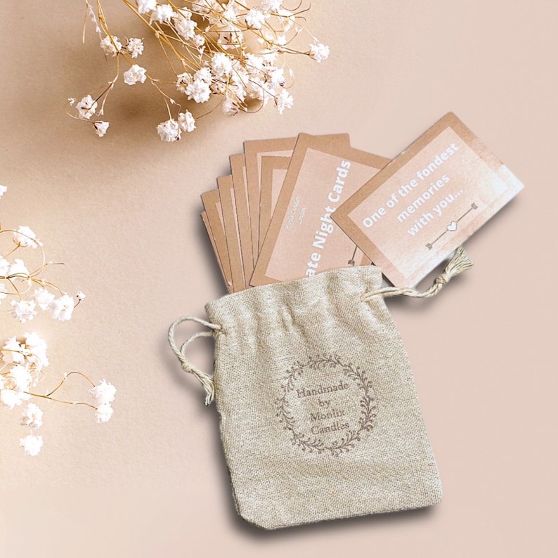 May include: A set of brown date night cards in a small burlap bag with a white logo that says "Handmade by Monlix Candles". The cards have white text that says "One of the fondest memories with you..." and "Date Night Cards".