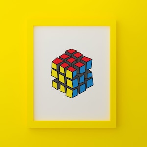 May include: A framed print showing a stylized illustration of a Rubik's Cube. The cube has red, yellow, and blue squares, outlined in black. The frame is yellow, set against a yellow background.