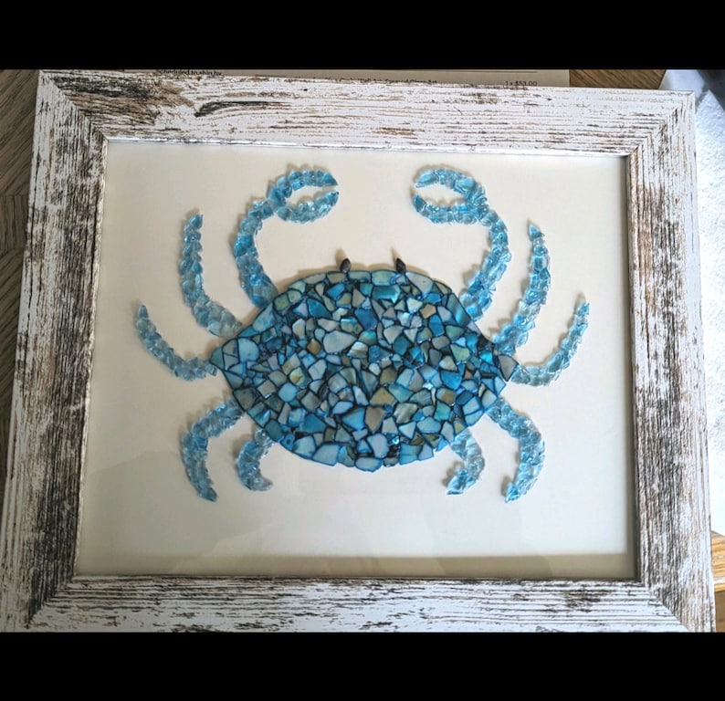 May include: A blue crab made of mosaic glass tiles, framed in a whitewashed wood frame.