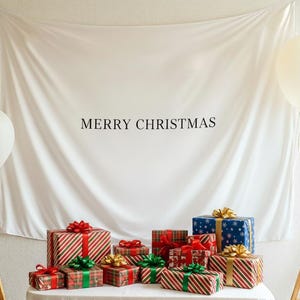 Może przedstawiać: Białe tło z napisem &bdquo;MERRY CHRISTMAS&rdquo; nad kolekcją zapakowanych prezent&oacute;w. Prezenty są w r&oacute;żnych rozmiarach i wzorach, z czerwonymi, zielonymi i złotymi wstążkami. Po obu stronach znajdują się białe balony.