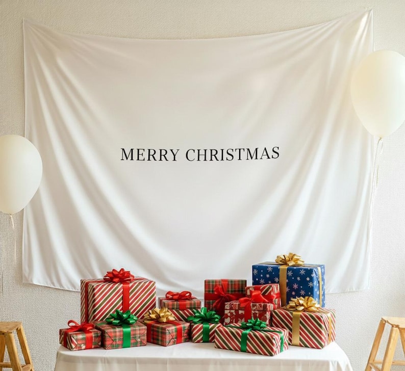 Może przedstawiać: Białe tło z napisem &bdquo;MERRY CHRISTMAS&rdquo; nad kolekcją zapakowanych prezent&oacute;w. Prezenty są w r&oacute;żnych rozmiarach i wzorach, z czerwonymi, zielonymi i złotymi wstążkami. Po obu stronach znajdują się białe balony.