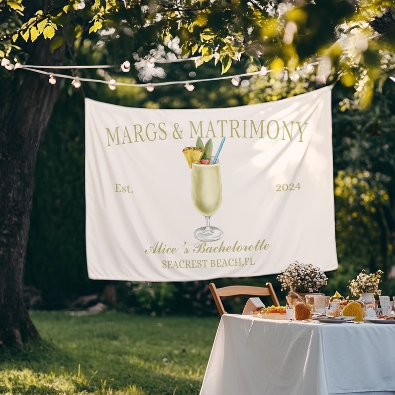 Op de afbeelding: Witte banner met de tekst "MARGS & MATRIMONY Est. 2024" en een tekening van een ananas-margarita. Onder de tekening staat de tekst "Alice's Bachelorette SEACREST BEACH, FL"