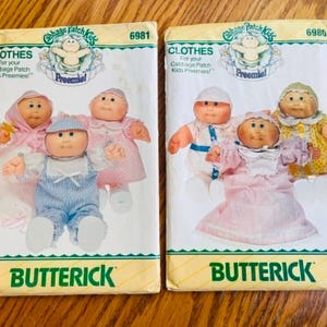 May include: Two vintage Butterick sewing pattern envelopes for Cabbage Patch Kids Preemies clothes. The envelopes feature illustrations of the dolls in various outfits. The patterns are labeled with the numbers 6981 and 6986.