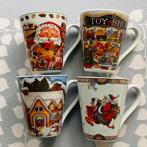 May include: Four ceramic mugs with Christmas-themed designs. The mugs feature Santa Claus, a toy shop, a winter scene, and a Santa Claus riding a reindeer. The mugs are white with colorful designs.