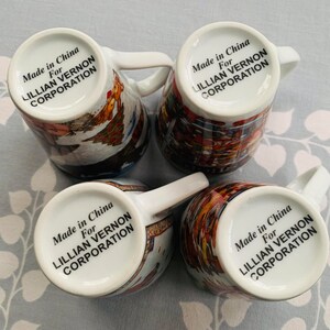 May include: Four white ceramic mugs with colorful designs and black text that reads "Made in China For Lillian Vernon Corporation" on the bottom of each mug.