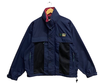 May include: A navy blue jacket with a mesh panel and a green and white logo that says "LOOGI" on the front. The jacket has a red lining and a drawstring at the bottom.