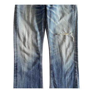 Pu&ograve; includere: Un paio di jeans blu con un ginocchio consumato. I jeans hanno un aspetto sbiadito e sono realizzati in un materiale morbido e confortevole.