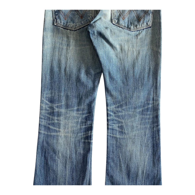 Pu&ograve; includere: Un paio di jeans blu in denim con dettagli sbiaditi e consumati. I jeans hanno una vestibilit&agrave; a gamba dritta e uno stile classico a cinque tasche.