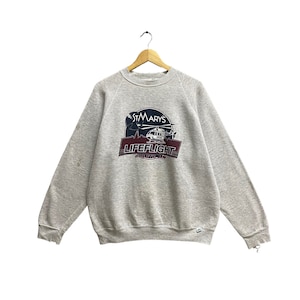 Sudadera unisex vintage St.Mary&#39;s Lifeflight de los años 90 con efecto desgastado en gris suave Suéter St.Mary&#39;s con cuello redondo y estampado de logotipo