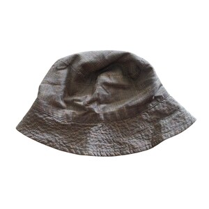 Puede incluir: Un sombrero de cubo de cuadros marrones y negros.