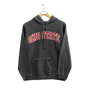 Può includere: Una felpa con cappuccio grigia con la scritta "Ohio State" in lettere rosse sul davanti.