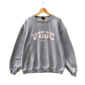 May include: Gray sweatshirt with a pink "VUJC NURSING" logo on the front.