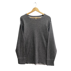 May include: A heather gray long-sleeve shirt with a crew neck and ribbed cuffs. The shirt is hanging on a wooden hanger against a white background. The fabric has a textured appearance.