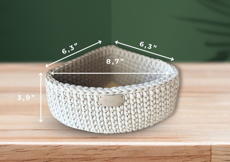 May include: A white crocheted storage basket with a rectangular label that says "Amolle" in silver lettering. The basket measures 8.7 inches wide, 6.3 inches long, and 3.9 inches high.