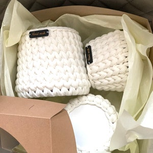 May include: Three white crocheted baskets with black labels that say "Handmade" in a brown box with white tissue paper.