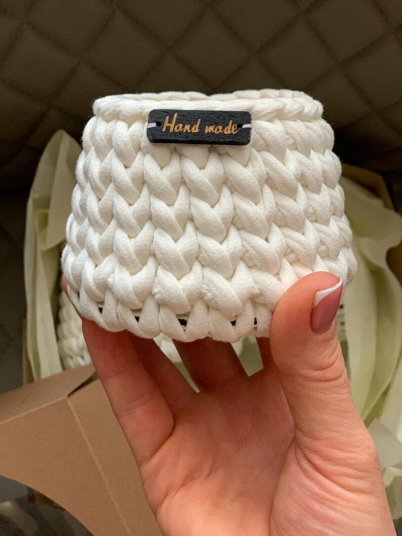 May include: White crocheted basket with a black tag that says "Hand made".