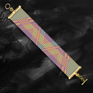 May include: A purple and gold beaded bracelet with a geometric pattern. The bracelet has a gold clasp and is on a black background.