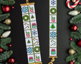 May include: Two beaded Christmas bracelets with gold-tone clasps. The white bracelets feature red, green, and blue holiday icons, including snowflakes, wreaths, candy canes, and gift boxes. Festive holiday jewelry.