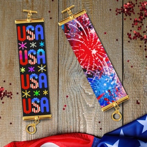 以下が含まれることがあります： 金色の留め具が付いたビーズブレスレットが2つ。1つのブレスレットには、赤、白、青の星で「USA」という単語が4回繰り返されています。もう1つのブレスレットには、赤、白、青の打ち上げ花火のデザインが施されています。